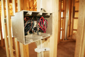 An electrical box with wiring inside a new construction house.